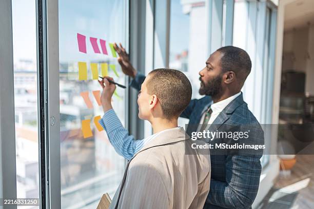 professionals collaborating on a creative project in a modern office setting - execution equipment stock pictures, royalty-free photos & images