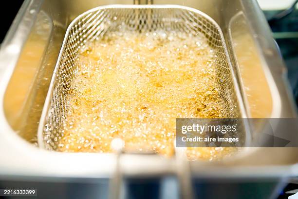 boiling oil in deep fryer basket cooking food - lubrificazione foto e immagini stock