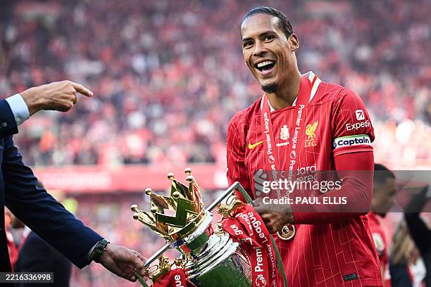 Liverpool's Dutch defender Virgil van Dijk celebrates with the Premier League trophy at the end of the English Premier League football match between...