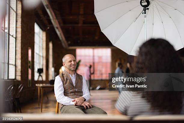 businessman smiling during an interview in a loft studio - audition camera stock pictures, royalty-free photos & images