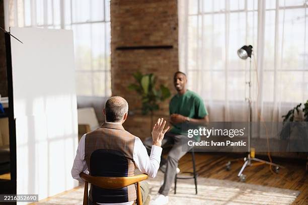 film director explaining scene to actor during movie shooting - casting director stock pictures, royalty-free photos & images