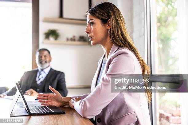business colleagues smiling and working together in modern conference room - formal businesswear stock pictures, royalty-free photos & images