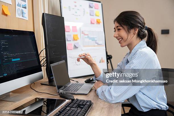 female programmer is writing code at her desk. - simulation training stock pictures, royalty-free photos & images