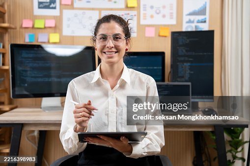 Female freelance developer coding and programming. Coding on two with screens with code language and application Female freelance developer coding and programming. Coding on two with screens with code language and application