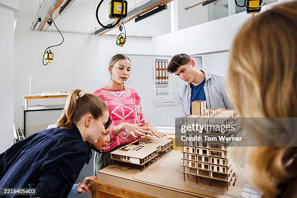 female architecture student explains structural details to peers using a scale model - scale model stock pictures, royalty-free photos & images