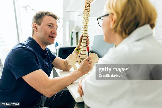 médicos examinando imágenes médicas en un consultorio clínico moderno - columna vertebral fotografías e imágenes de stock