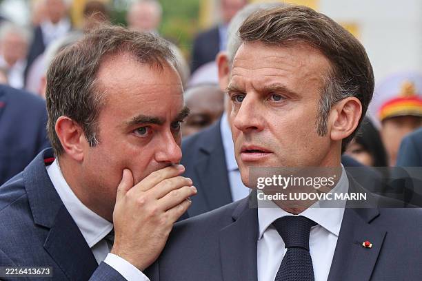France's President Emmanuel Macron speaks with France's Minister of Armed Forces Sebastien Lecornu after taking part in a wreath-laying ceremony at...