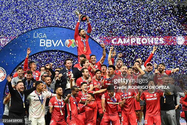 Toluca's forward Alexis Vega lifts the trophy with teammates during a ceremony for the Mexican Champions following the Liga MX Clausura football...