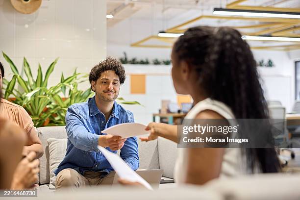colleague taking document from manager - formulier stockfoto's en -beelden
