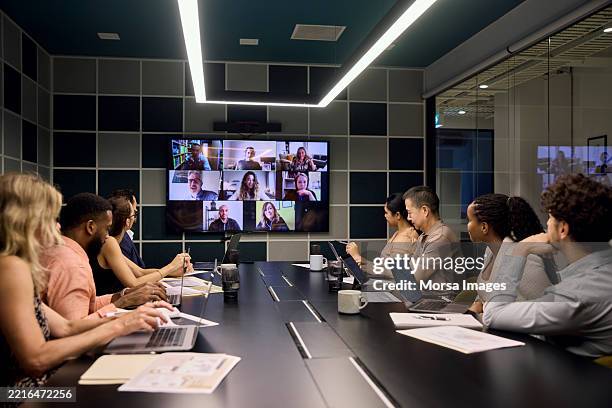 business people on video conference sharing ideas - vergaderruimte stockfoto's en -beelden