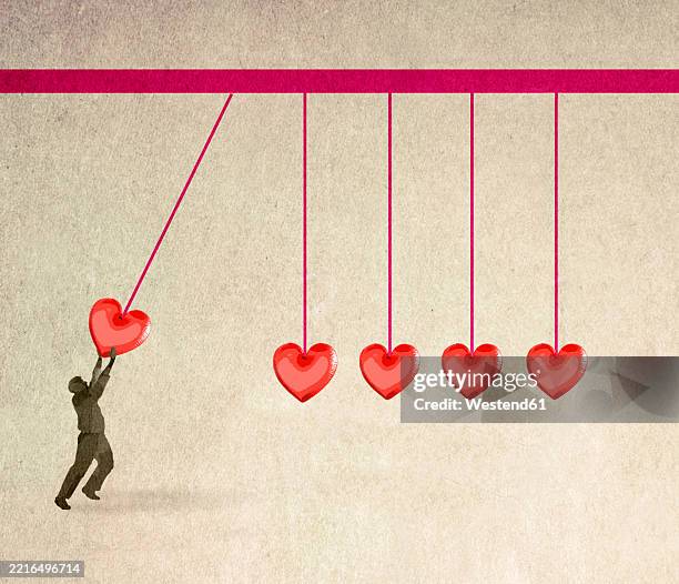 illustration of man starting oversized newtons cradle composed of hearts - pendel stock-grafiken, -clipart, -cartoons und -symbole