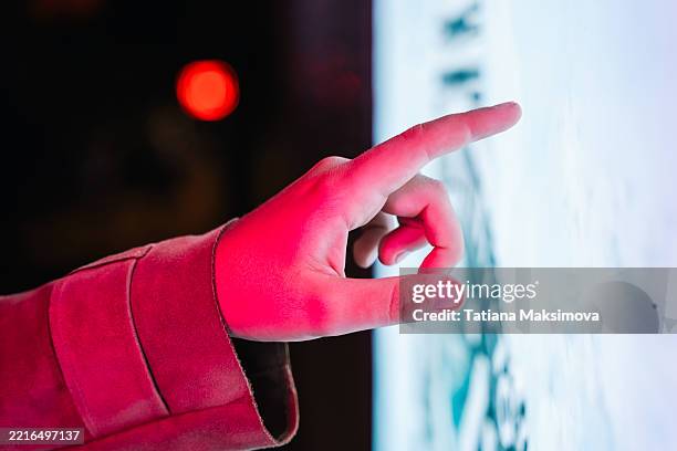 a finger touches a digital screen glowing with soft blue light, highlighted by a neon pink sleeve. the gesture symbolizes modern interaction, choice, and smart interfaces. - finger snapping stock pictures, royalty-free photos & images