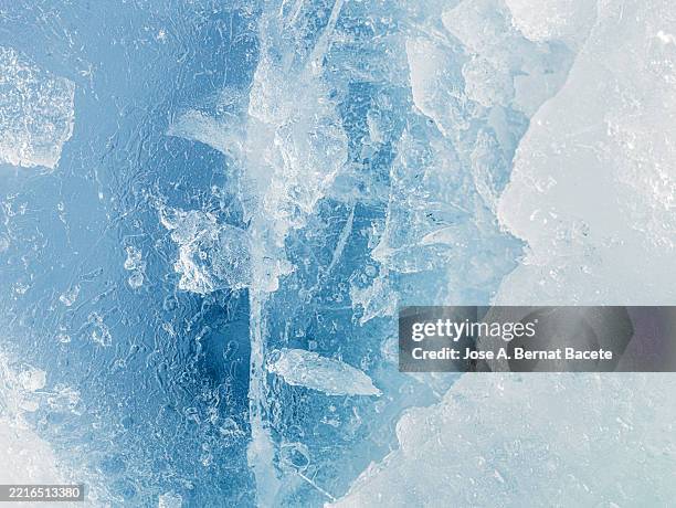full frame of a surface with broken and cracked ice blocks in turquoise blue tones. - glace photos et images de collection