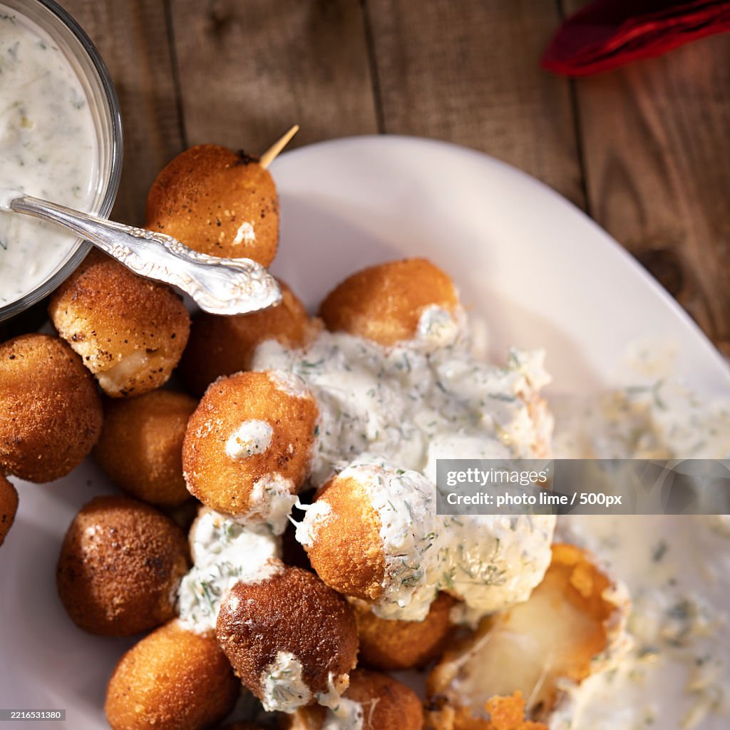 Round fried mozzarella cheese sticks under creamy sauce Top view