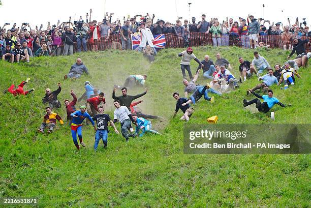 Participants take part in the annual cheese rolling at Cooper's Hill in Brockworth, Gloucestershire. Picture date: Monday May 26, 2025.