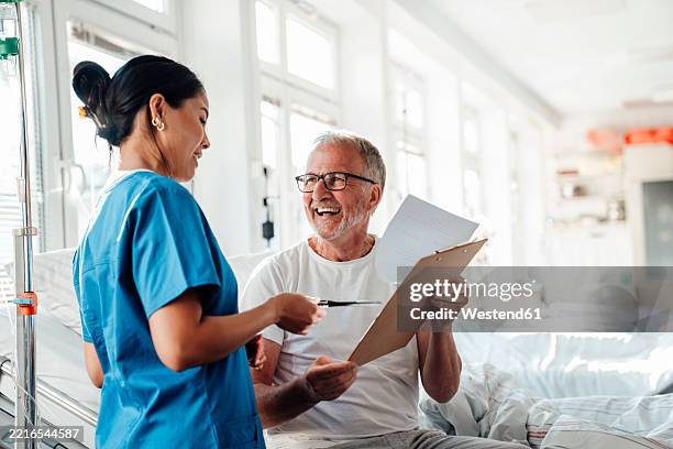nurse providing care and advice to a patient in a hospital setting - prevención de enfermedades fotografías e imágenes de stock