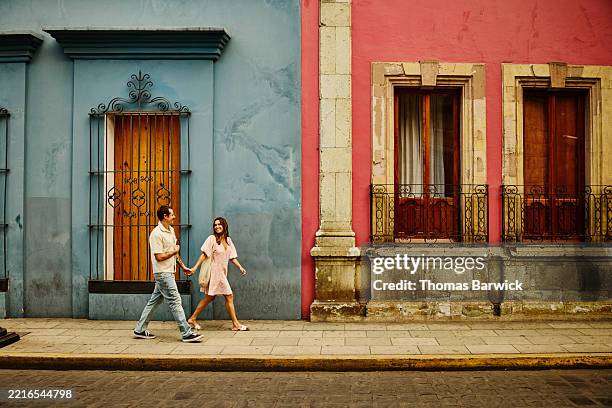 wide shot energetic couple discovering old town oaxaca during vacation - honeymoon stock pictures, royalty-free photos & images
