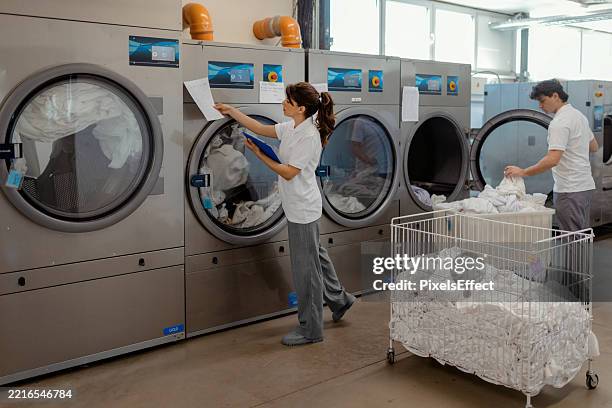 industrial linen processing in a commercial facility - laundromat stock pictures, royalty-free photos & images