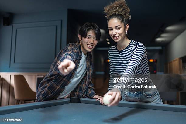 young couple playing billiards and having fun together in a pub - pool table top view stock pictures, royalty-free photos & images