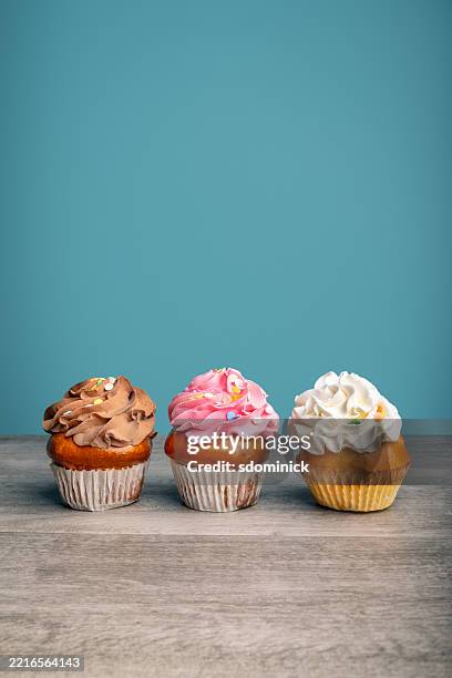 three cupcakes with buttercream icing with room for copy - cupcake stock pictures, royalty-free photos & images