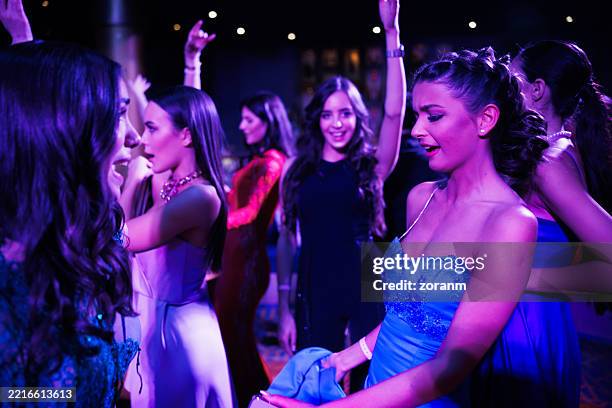 cheerful young women dancing and singing under the purple neon light in the night club - ladies night stock pictures, royalty-free photos & images