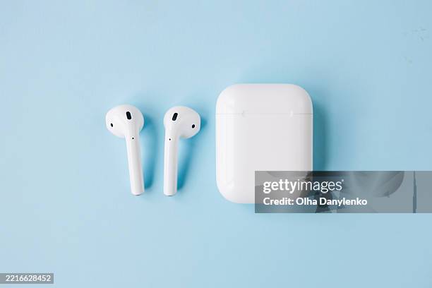 wireless bluetooth headphones on blue background - kopfhörer freisteller stock-fotos und bilder