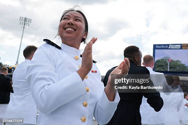 Naval Academy graduates celebrate after the Blue Angels fly over during the 2025 Naval Academy Graduation and Commissioning Ceremony on May 23, 2025...
