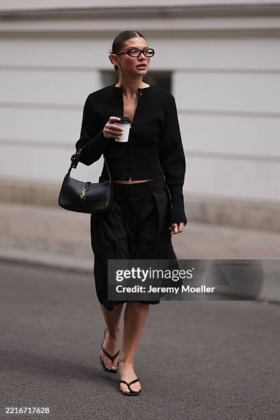 Sophia Geiss is seen wearing silver hoop earrings in two different sizes, oval brown glasses from Corlin, a silver nose ring, a black ribbed-knit...