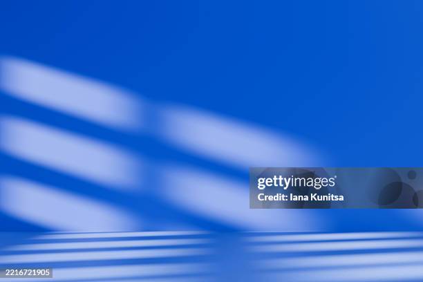 minimalist abstract 3d background in blue with shadows and diagonal light patterns on wall. modern geometric composition, contrast, simplicity. place for text, and designs. - iluminación gobo fotografías e imágenes de stock