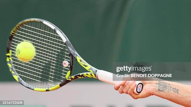 Tennis racket hits a ball during a match between Belgian Wickmayer and Belarusian Azarenka in the first round of the Women's Singles at the Roland...