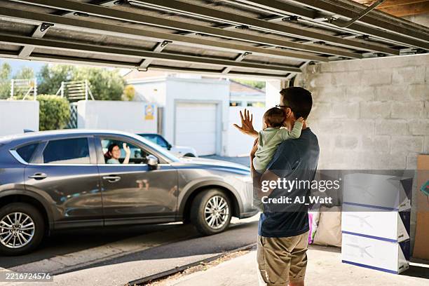 father and baby waving goodbye to mother leaving home by car - auto interieur stockfoto's en -beelden