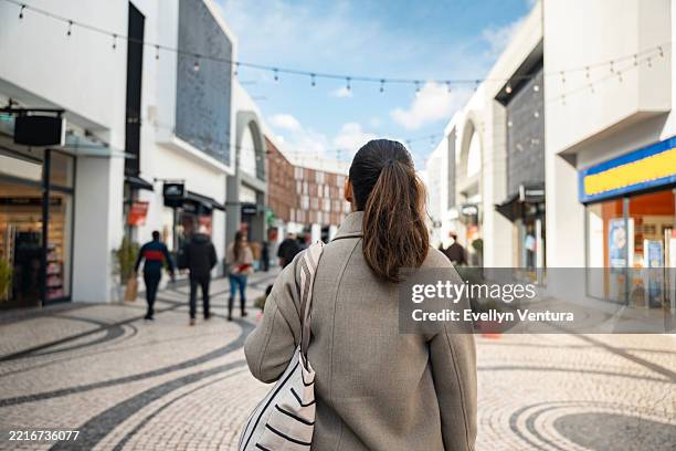 vista trasera de una mujer de compras en un mercado callejero - lugar de comercio fotografías e imágenes de stock
