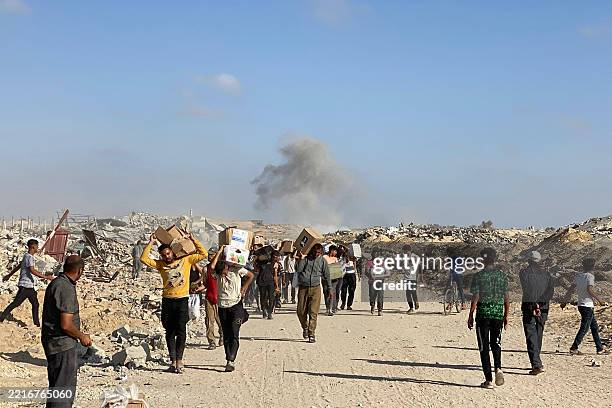 Displaced Palestinians receive food packages from a US-backed foundation pledging to distribute humanitarian aid in western Rafah in the southern...