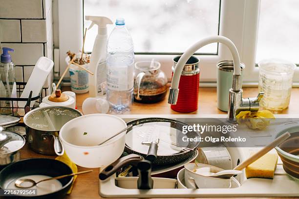 dirty dishes piling up in kitchen sink after meal - amontoar imagens e fotografias de stock