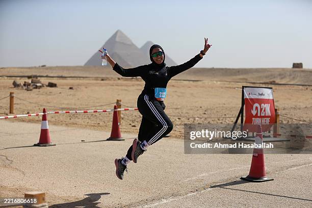 Runners pose in front of the pyramids as they participate in the "One Run" race at the Pyramids during the One Run race on May 24, 2025 near the...
