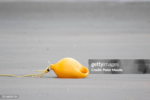 a yellow bouy on west wittering beach - bouy stock pictures, royalty-free photos & images