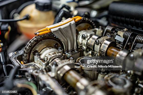 nahaufnahme von internen komponenten des automotors, einschließlich nockenwelle und ketten - motor stock-fotos und bilder