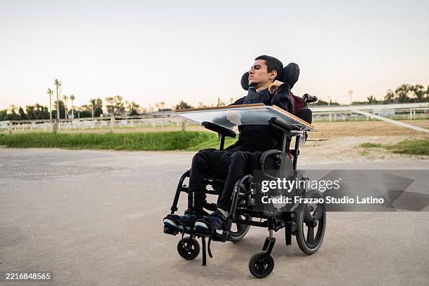 young man with cerebral palsy outdoors - paralysis stock pictures, royalty-free photos & images