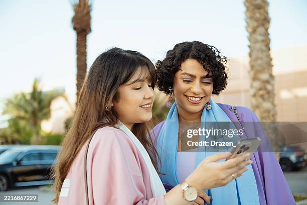 beaux voyageurs arabes à l’extérieur à l’aide d’un téléphone intelligent et d’un gps mobile dans la ville - culture saoudienne photos et images de collection
