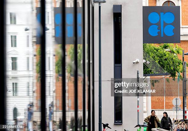 People walk by the building headquarters of OPEC as the logo is seen on its facade in Vienna, Austria on May 28 as Ministers of the OPEC+ oil...