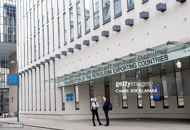 People stand outside the building headquarters of OPEC in Vienna, Austria on May 28 as Ministers of the OPEC+ oil alliance, led by Saudi Arabia and...