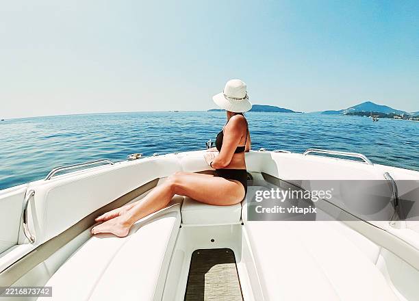 mujer relajándose en un yate de lujo rodeado de aguas azules del océano - exclusivo fotografías e imágenes de stock