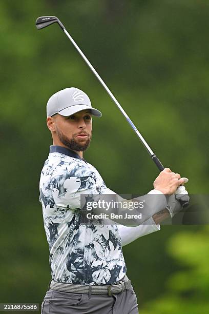 Stephen Curry, NBA player for the Golden State Warriors plays a tee shot on the ninth hole prior to the Memorial Tournament presentedy by Workday at...