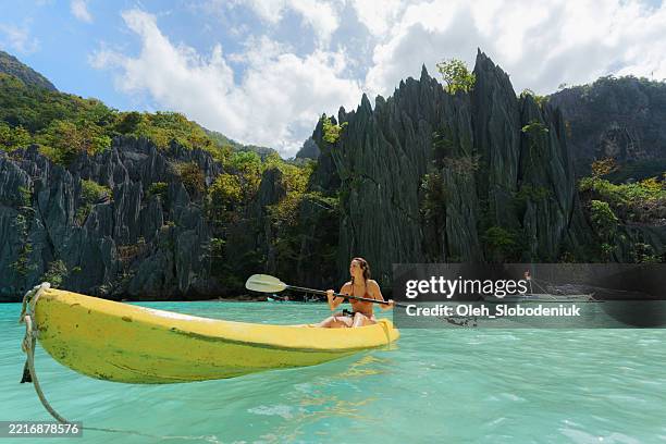 carefree woman kayaking on el nido, philippines - el nido stockfoto's en -beelden