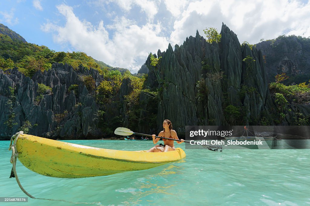 Carefree woman kayaking on El Nido, Philippines