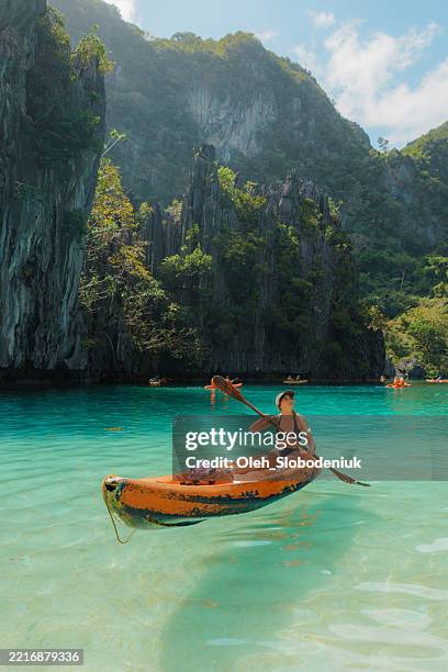 carefree woman kayaking on el nido, philippines - el nido stockfoto's en -beelden