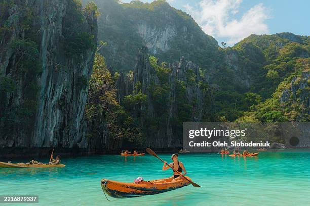 carefree woman kayaking on el nido, philippines - el nido stockfoto's en -beelden