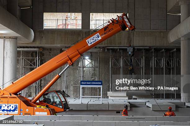 Construction workers lower a precast platform slab during the installation of the first high speed railway platforms for the HS2 project at Old Oak...