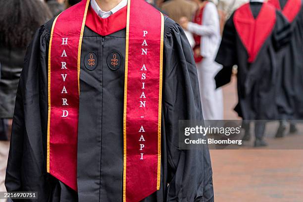 Harvard University students wearing graduation gowns walk through Harvard Square in Cambridge, Massachusetts, US, on Thursday, May 29, 2025. US...