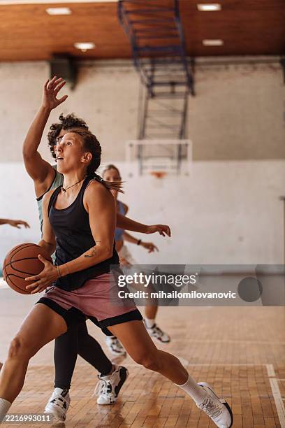 focused female basketball team in intense indoor game - basketball team stock pictures, royalty-free photos & images